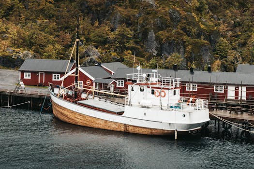 A traditional fishing boat docked at a quaint Nordic harbor surrounded by lush greenery.