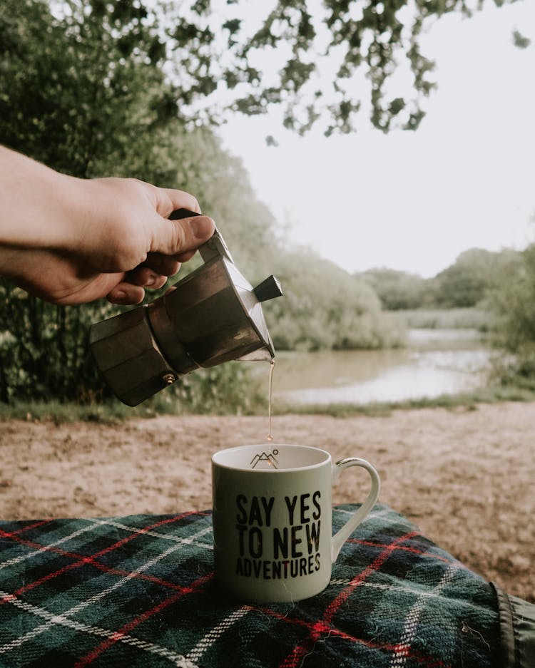 Person Pouring Tea In Cup