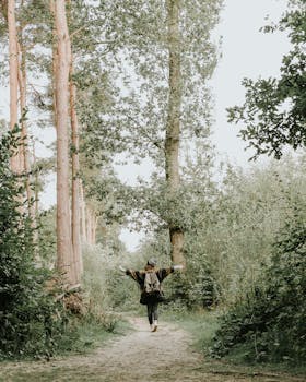 一位妇女兴高采烈地走在绿树环绕的宁静森林小路上