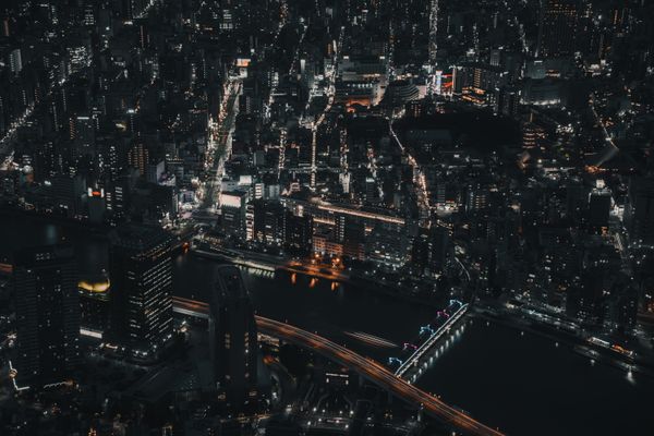 Uma visão aérea cativante do brilho da paisagem urbana de Tóquio à noite, destacando a vida urbana e a arquitetura.