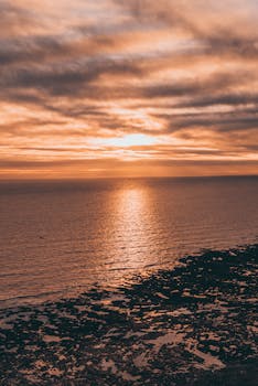 海上的日落令人惊叹，云层壮观，营造出一片宁静祥和的景象