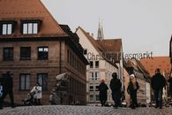 A bustling street view of Nuremberg's historic Christmas market during winter.