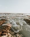 日落时分，海浪轻拍岩石，宁静的海景非常适合作为夏季旅行图像