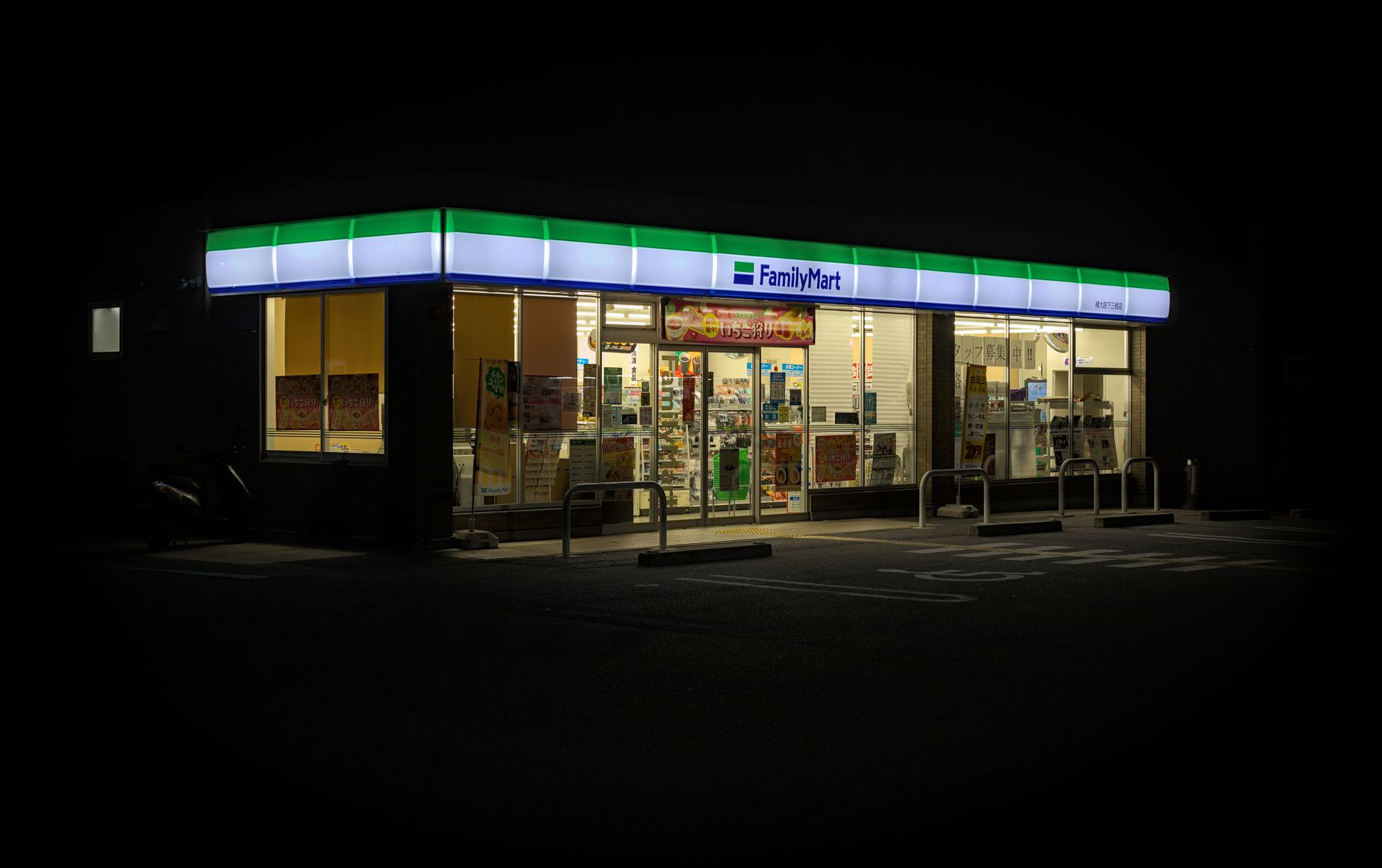 Nighttime view of a brightly lit FamilyMart convenience store in Kyoto, Japan, showcasing urban nightlife.