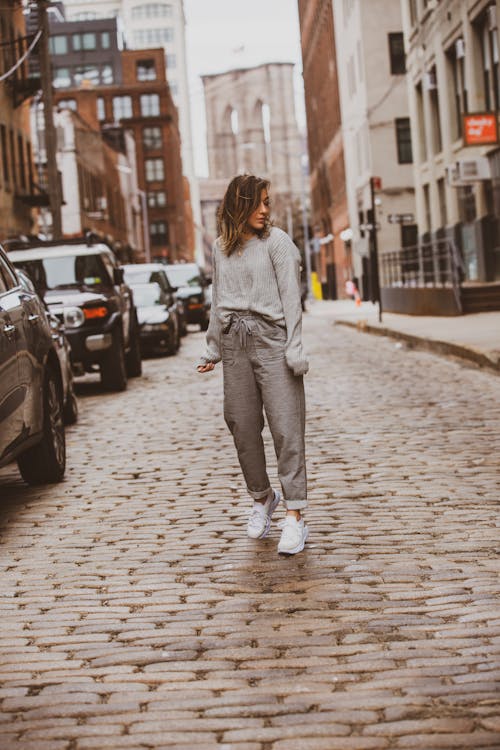 Woman in Gray Sweater and Gray Sweatpants Standing Outdoors