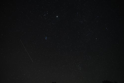 Free Explore the mesmerizing night sky filled with stars and a meteor streak in this captivating image. Stock Photo