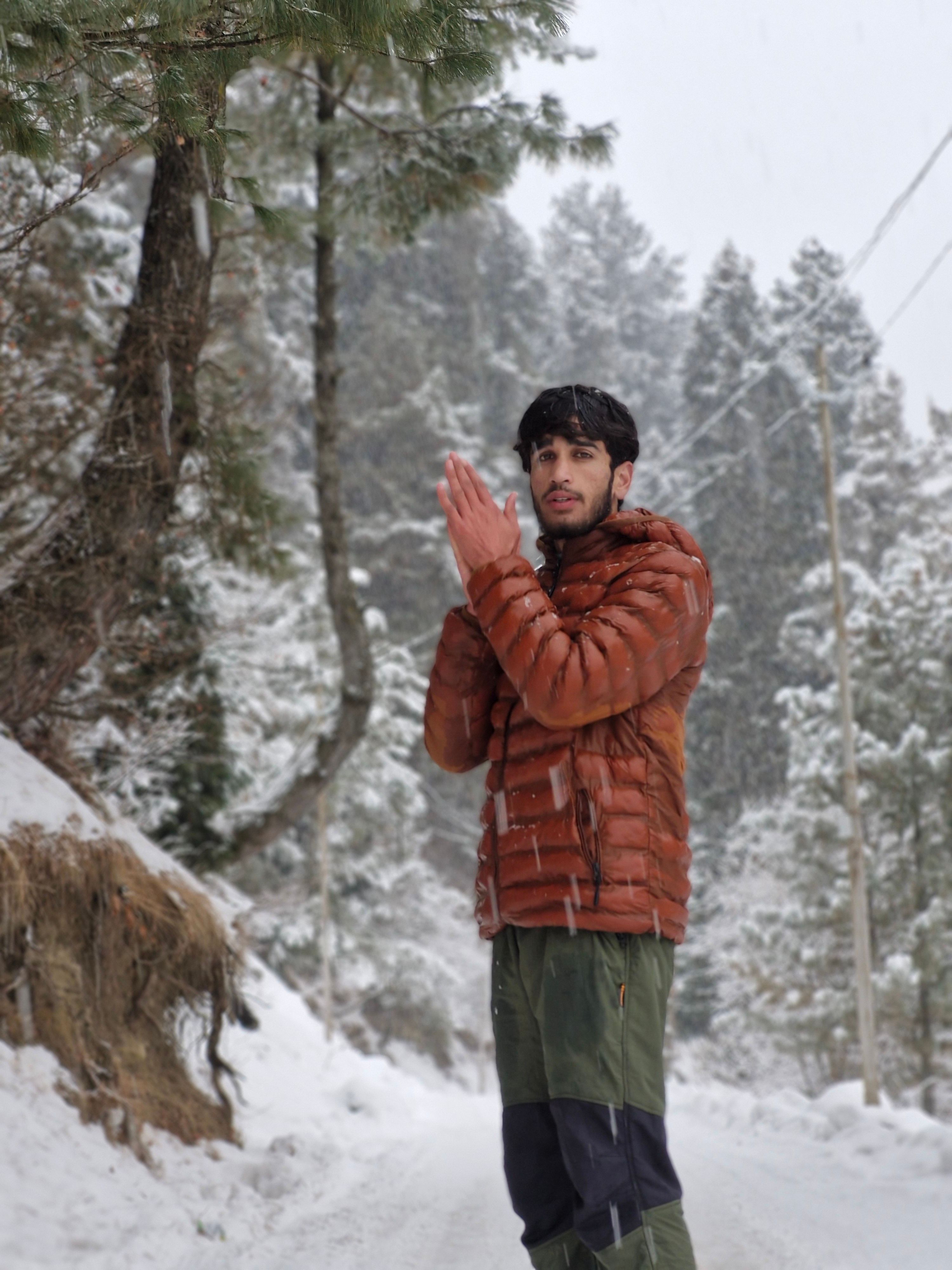 Man in Winter Jacket Walking Through Snowy Forest · Free Stock Photo