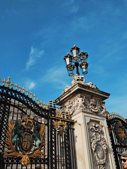 Free Elegant ornate gate of a palace under a clear blue sky, showcasing intricate metalwork and classic architecture. Stock Photo