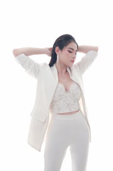 Portrait of a woman in a fashionable white ensemble with a serene pose, highlighting elegance and style.