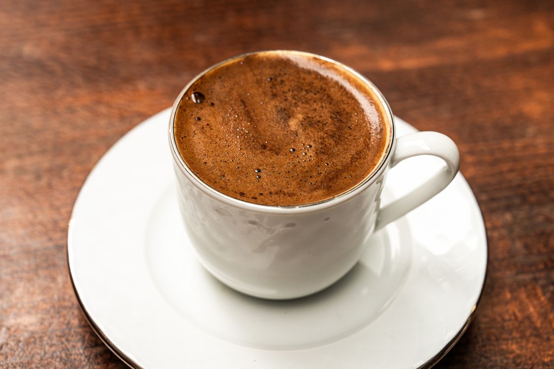 Free A steaming cup of strong Turkish coffee in a white cup, perfect for a caffeine boost. Stock Photo