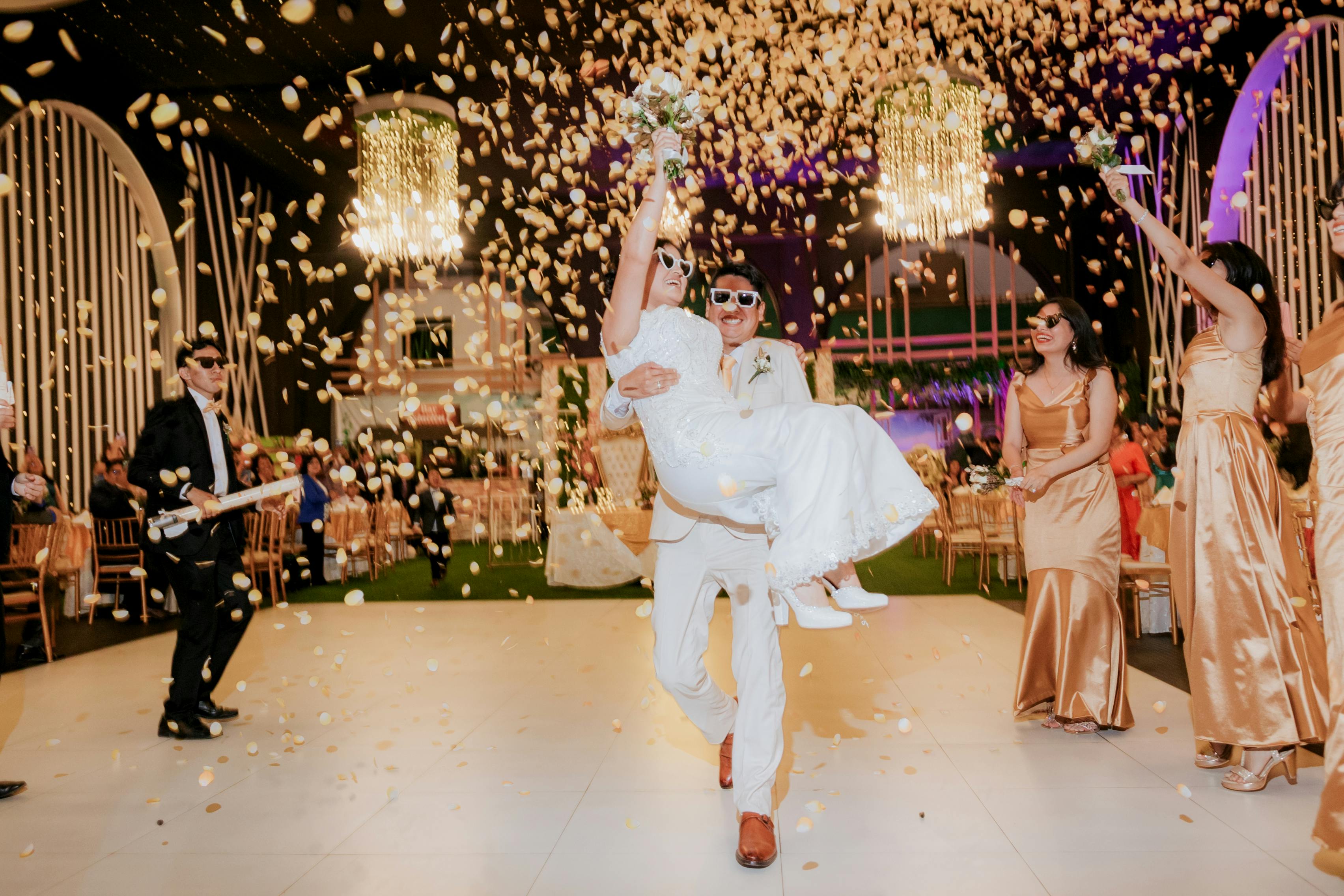 Cascading flower petals over a celebrating couple — the plugged-in reception in its loudest moment