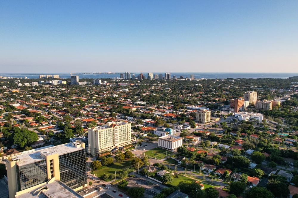 Aerial daytime view of Miami, Florida capturing city skyline and distant ocean.