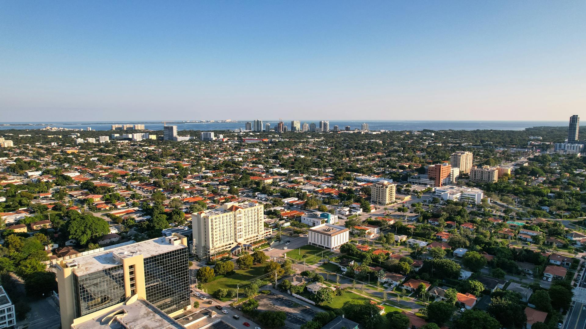 Aerial daytime view of Miami, Florida capturing city skyline and distant ocean.