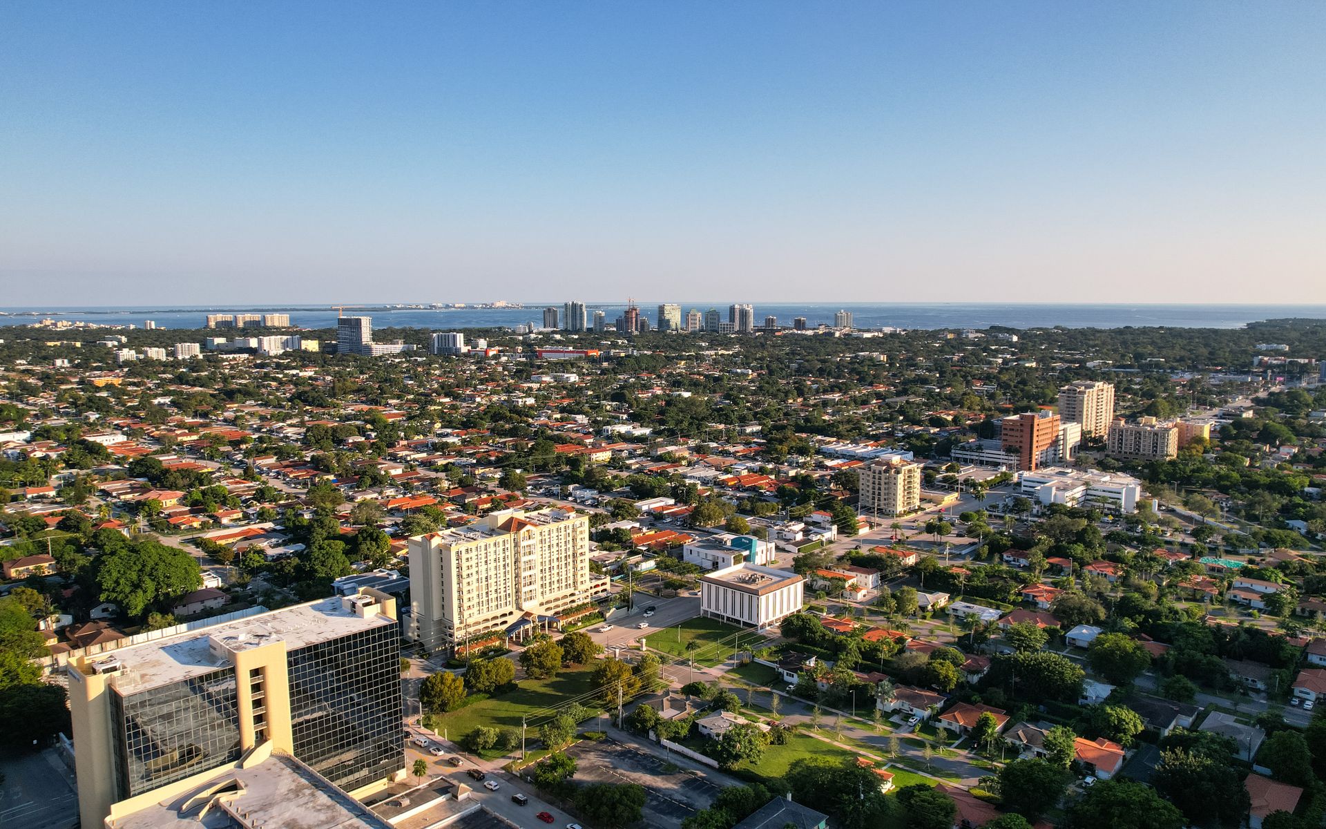 Aerial daytime view of Miami, Florida capturing city skyline and distant ocean.
