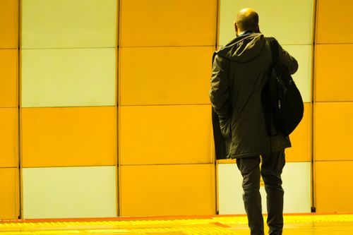 Free A man standing at an İstanbul subway station with a yellow wall background. Stock Photo