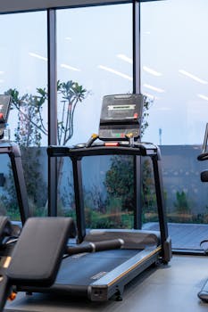 Modern treadmills in a gym with a scenic twilight view in Dubai.