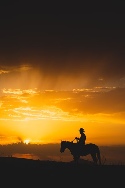 Silhouette of a cowboy riding a horse against a stunning sunset in Ardıç, Kayseri.