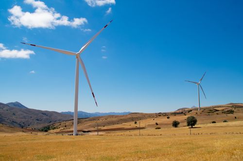 Free Vibrant landscape with wind turbines generating renewable energy under a clear blue sky. Stock Photo