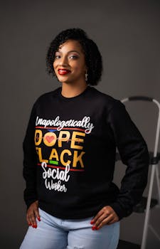 Portrait of a confident woman wearing a social worker sweatshirt with vibrant design.