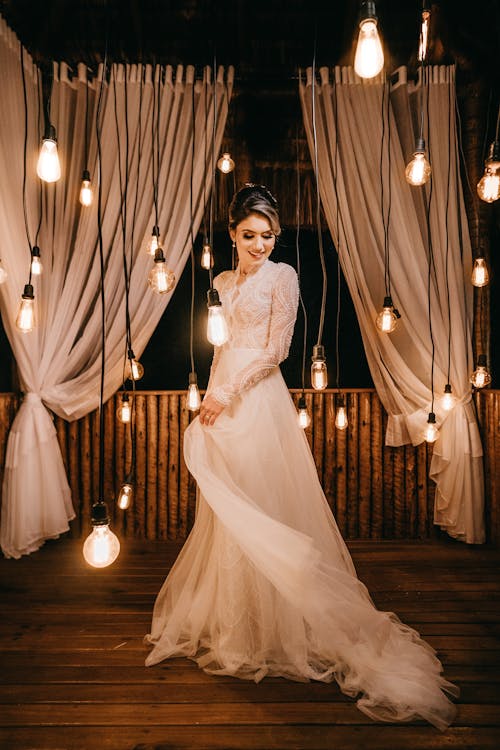 Woman Standing Beside Hanging Light Bulbs