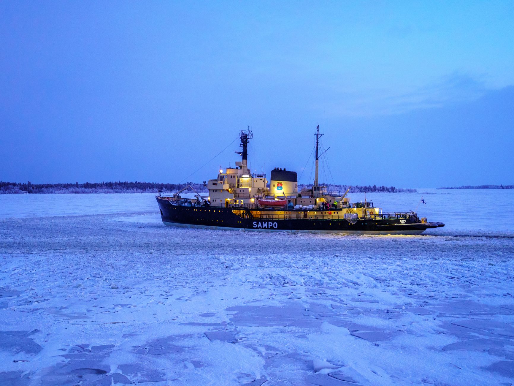 Explore the Icebreaker Sampo navigating through the icy waters of Kemi, Finland at sunset.