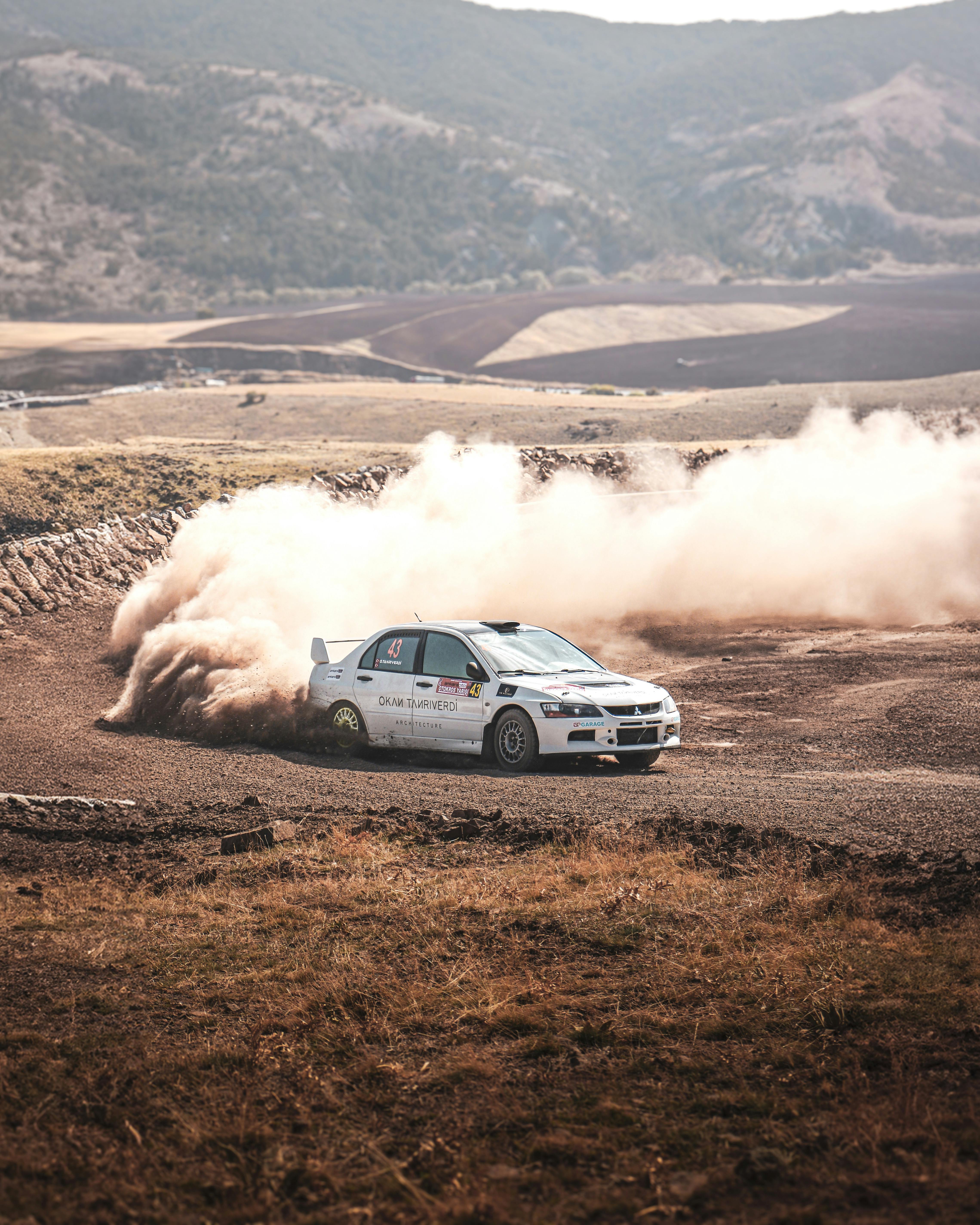 Rally car races through dirt track in Beynam, Ankara, Türkiye, creating a dusty trail.