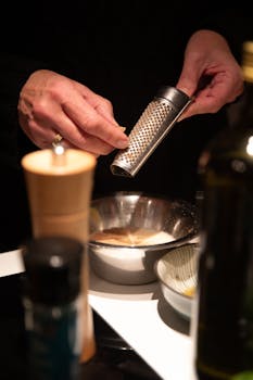 Close-up of a chef grating spice into a bowl, creating a cozy culinary moment.