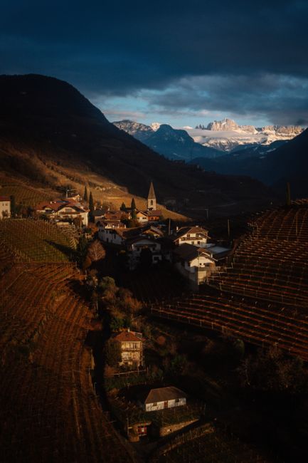 Picturesque view of a village in Bolzano, Italy, set against the stunning Alps landscape.