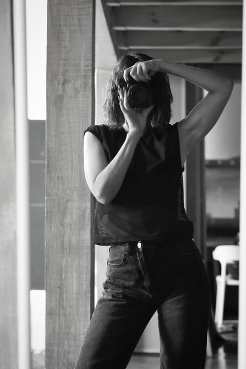 Free Black and white photo of a stylish woman taking a self-portrait indoors. Stock Photo