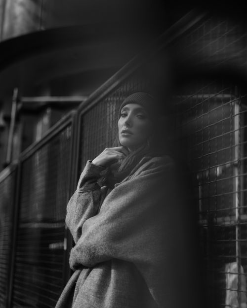 Free Moody black and white portrait of a woman standing in an urban setting. Stock Photo