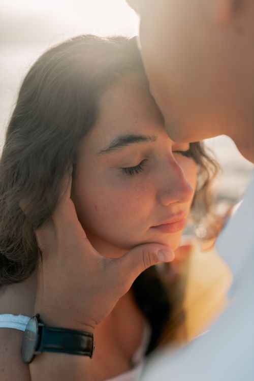 Free A gentle loving gesture between a couple at sunset, capturing intimacy and serenity. Stock Photo