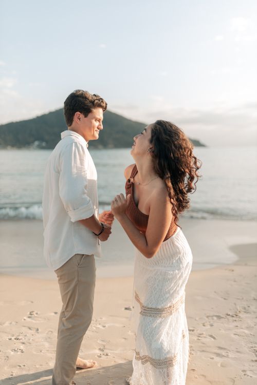 Free A happy couple enjoying a romantic moment by the beach at sunset. Stock Photo