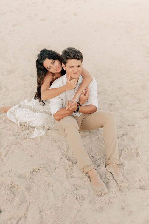Free A loving couple embracing on a sunlit beach, enjoying a peaceful moment. Stock Photo