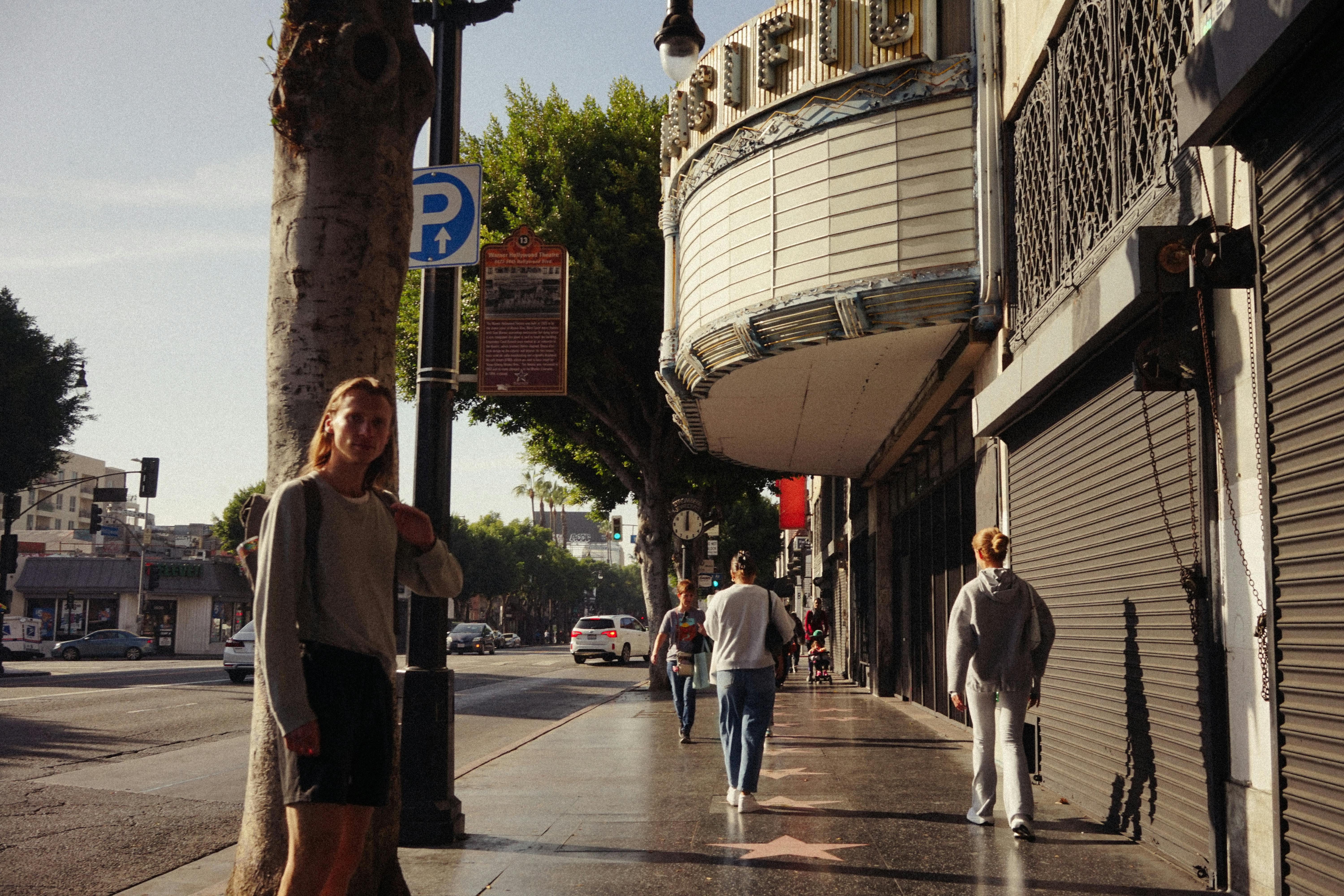gratis Mensen wandelen langs een klassiek theater in een stedelijke straatomgeving en vangen de lokale cultuur vast. Stockfoto
