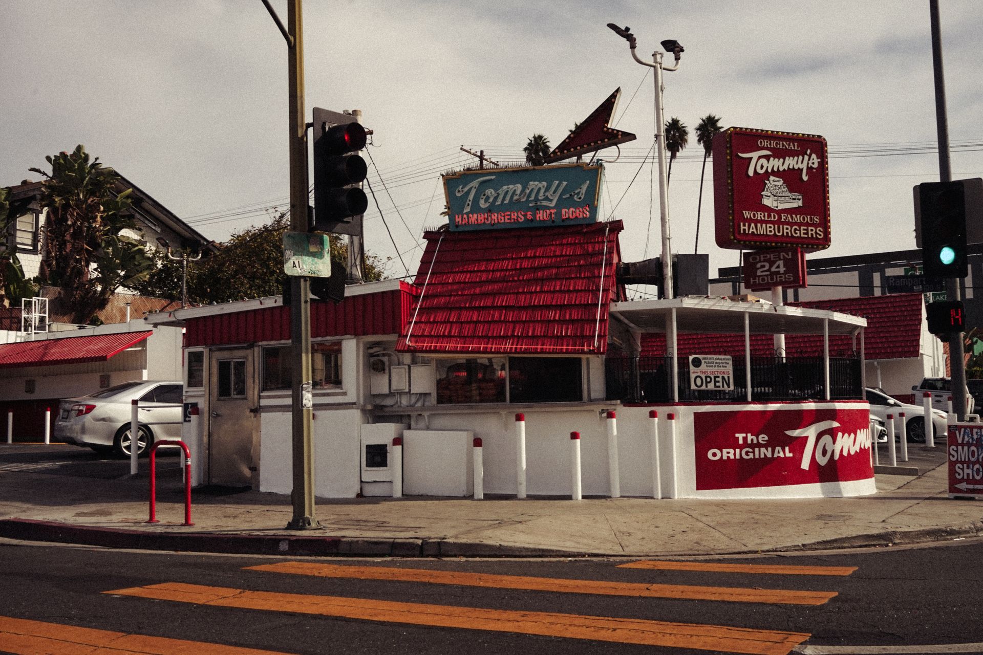 Classic American diner on a street corner, showcasing retro signage and vibrant red accents on a sunny day.