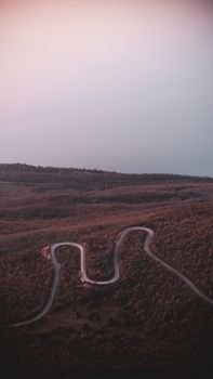 Aerial view of a winding road through Galicica National Park at sunset, North Macedonia.