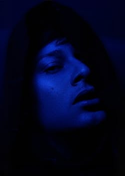 A striking portrait with deep blue tones capturing an enigmatic expression.