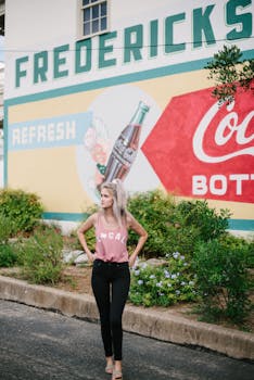 一名充满活力又时尚的女子在弗雷德里克斯堡的可口可乐主题壁画旁摆姿势