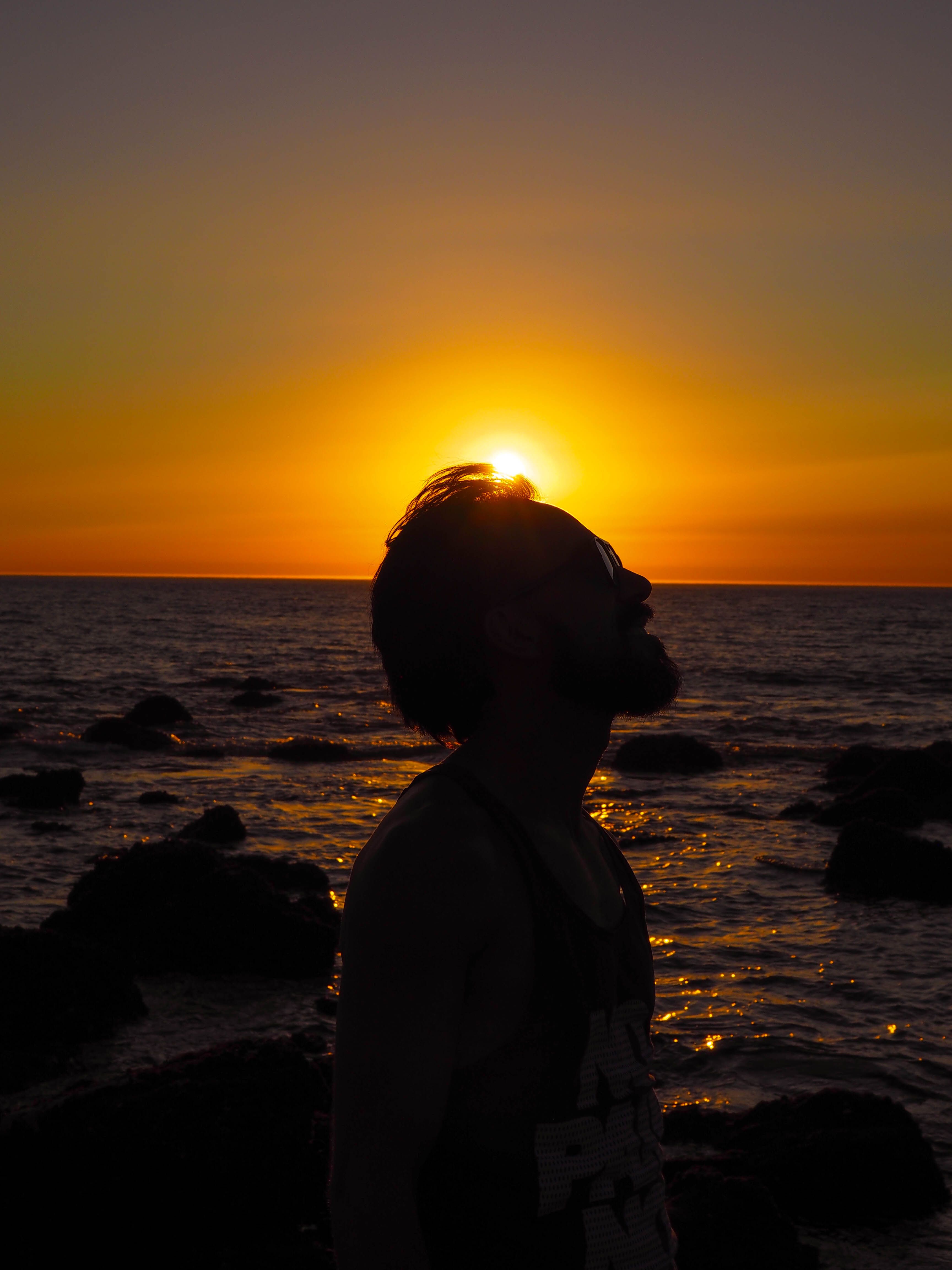 Silhouette of a Man at Sunset by the Ocean · Free Stock Photo