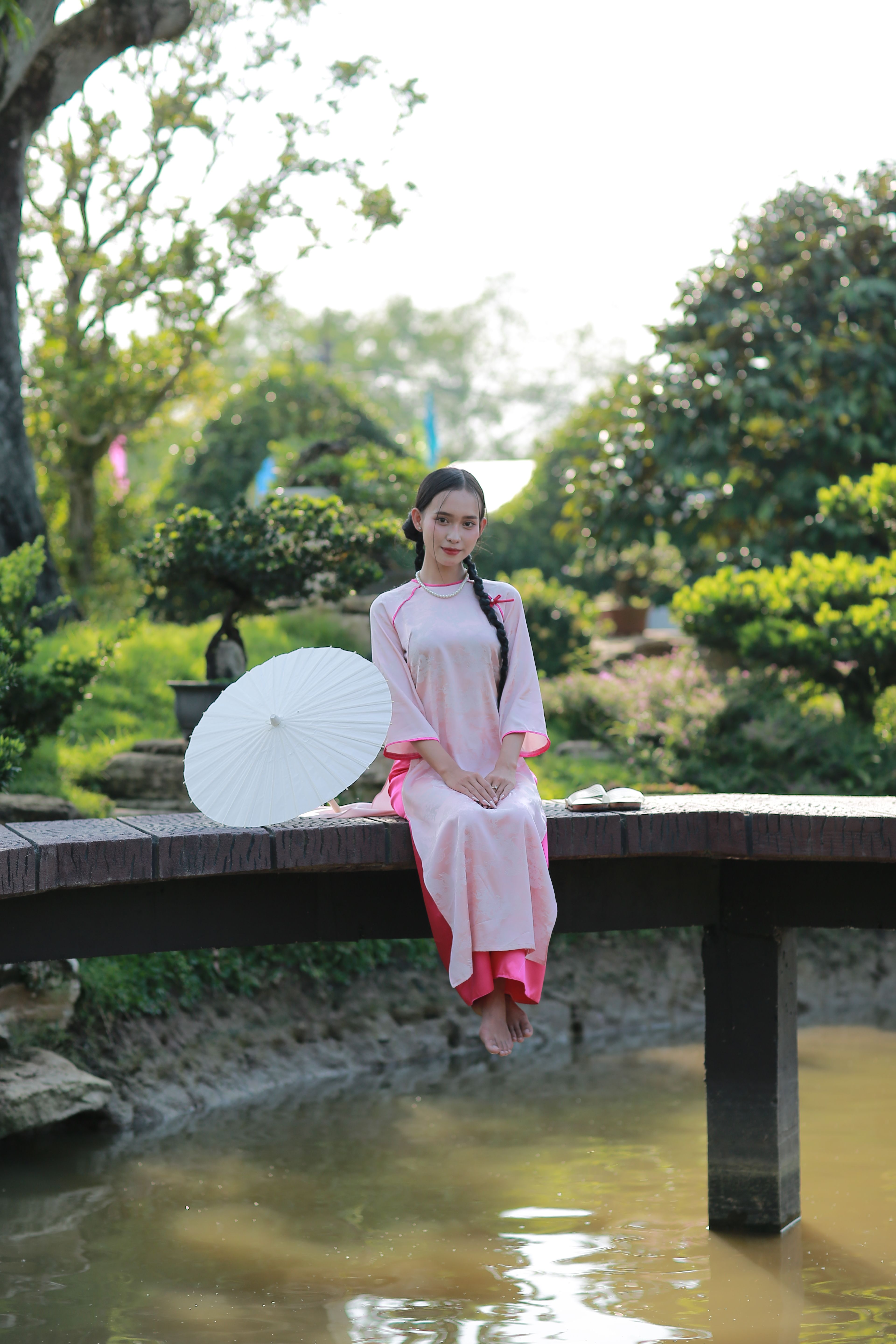 Young Woman in Traditional Dress on Garden Bridge · Free Stock Photo