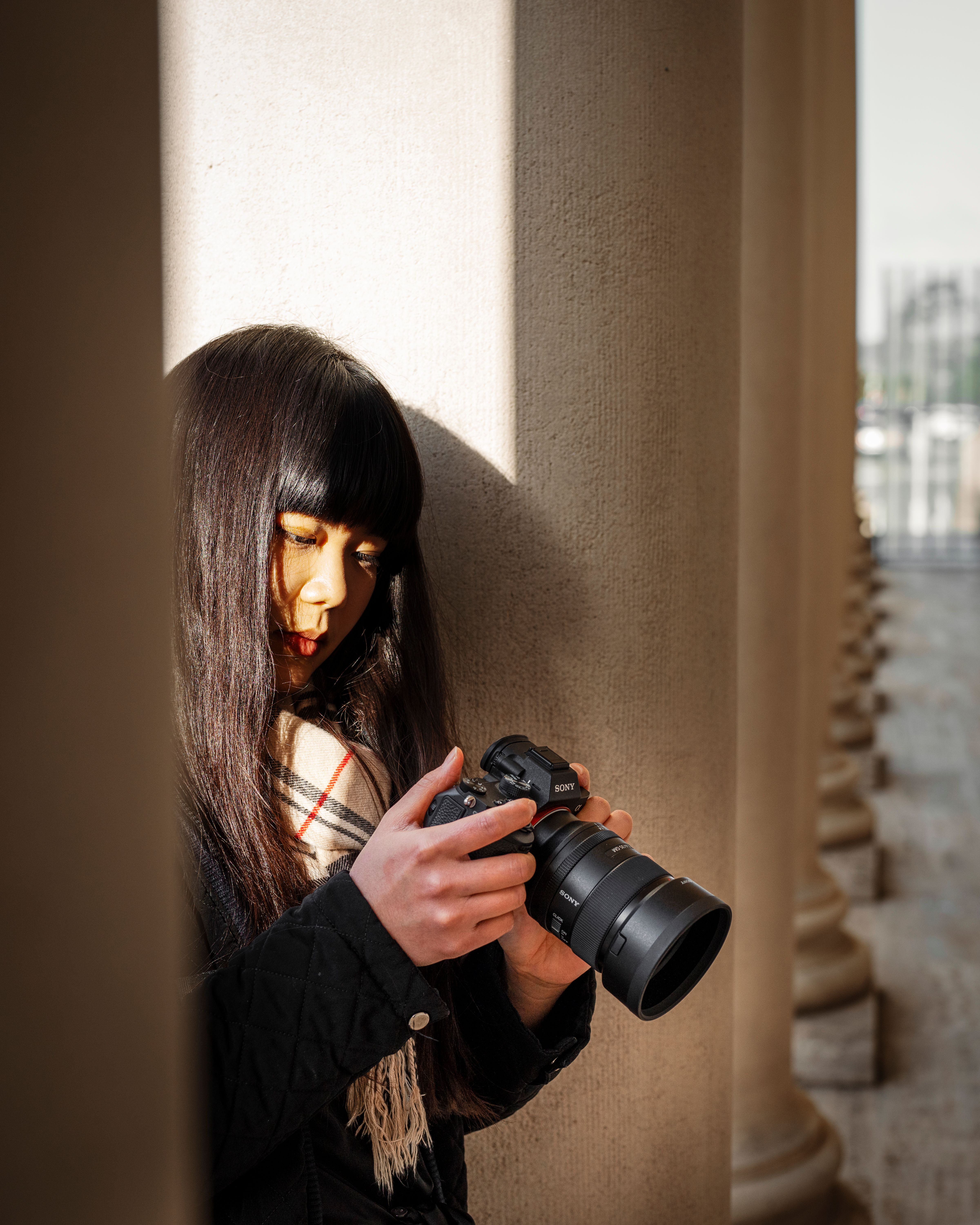 Woman photographing in columned architecture in San Francisco.