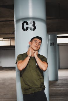 Confident young man posing by a C3 pillar in a parking garage.