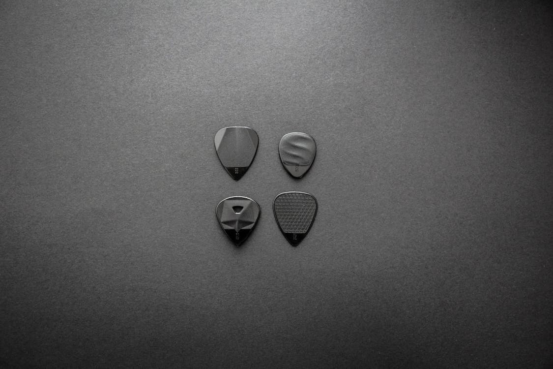 Grayscale Photography of Four Guitar Picks