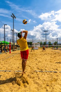 Dynamic beach volleyball game in Koper, Slovenia under a bright sunny sky.