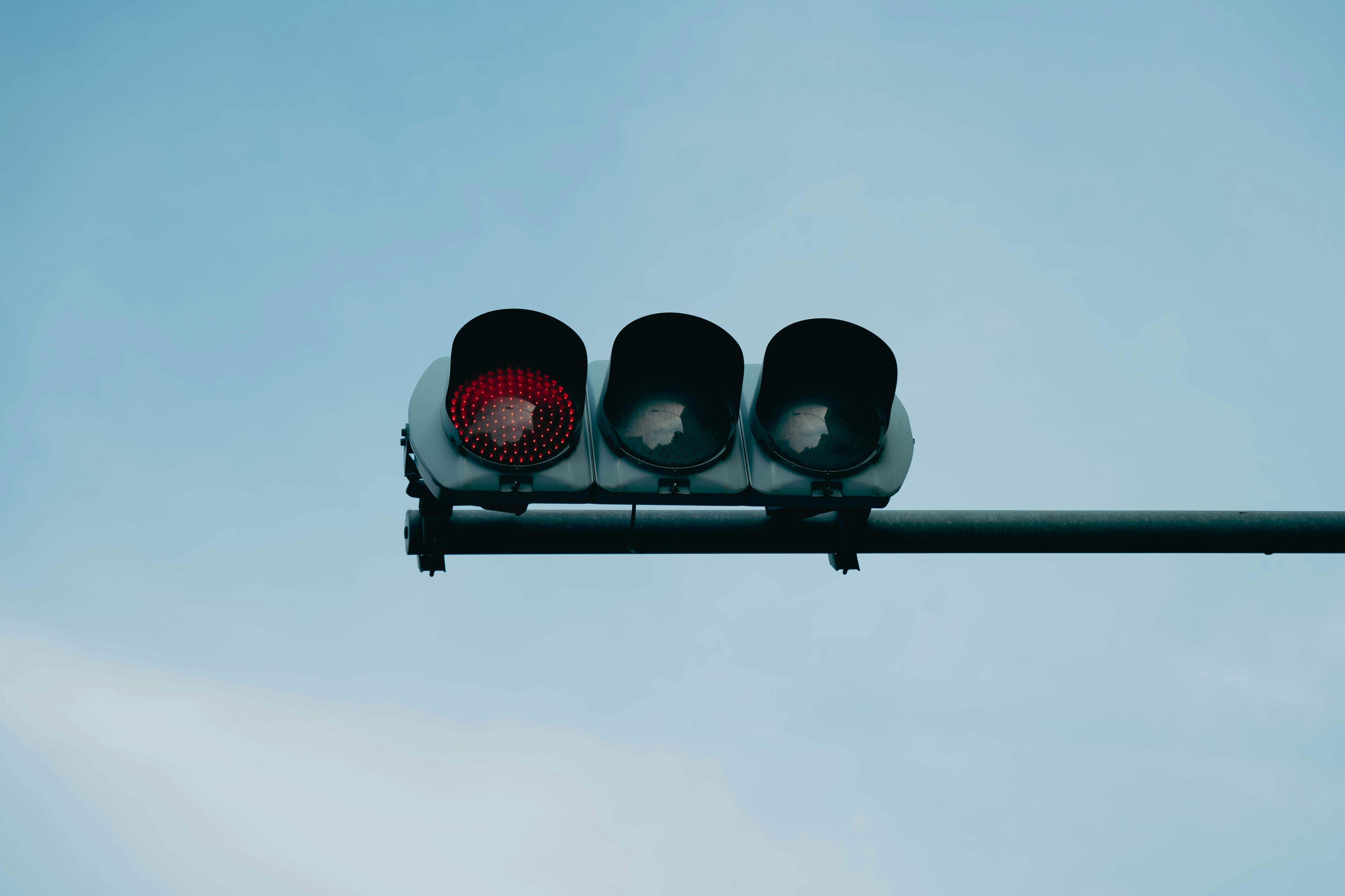 Gratuit Un prim-plan al unui semafor roșu plasat pe un cer albastru senin, care transmite siguranță și prudență. Fotografie de stoc