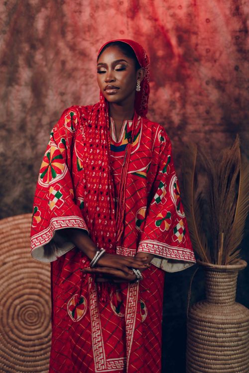 Free Fashion portrait of a woman in traditional red attire with cultural accessories. Stock Photo