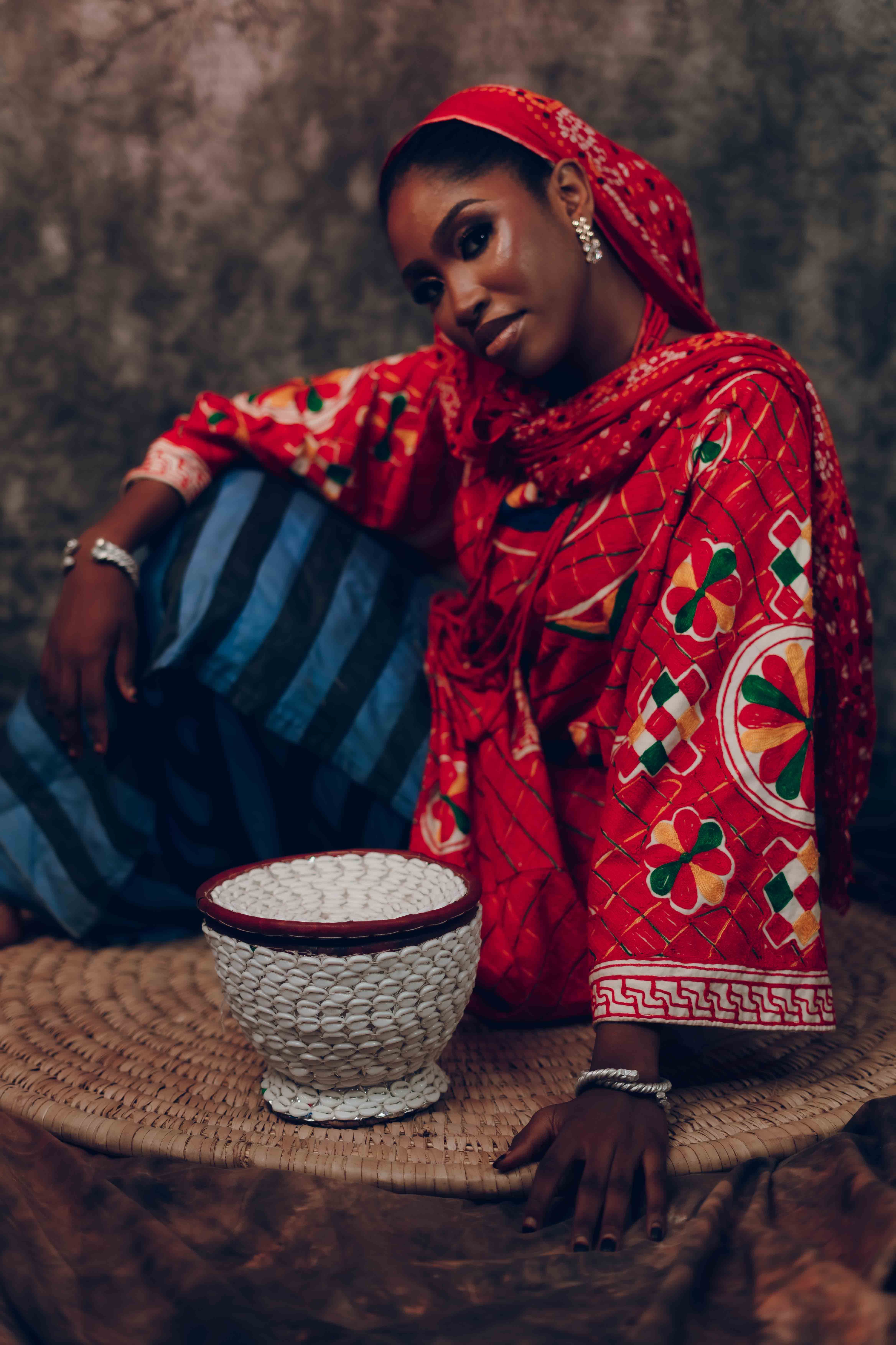 Captivating portrait of a woman in vibrant traditional African attire with ornate patterns.