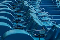 户外环境中，有一排空的蓝色踏板船，船上带有方向盘