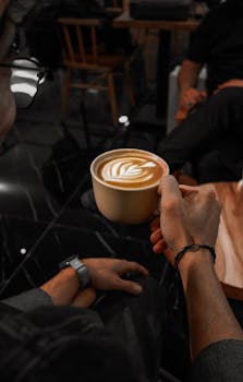 A person enjoying a latte with beautiful coffee art in a relaxing cafe setting.