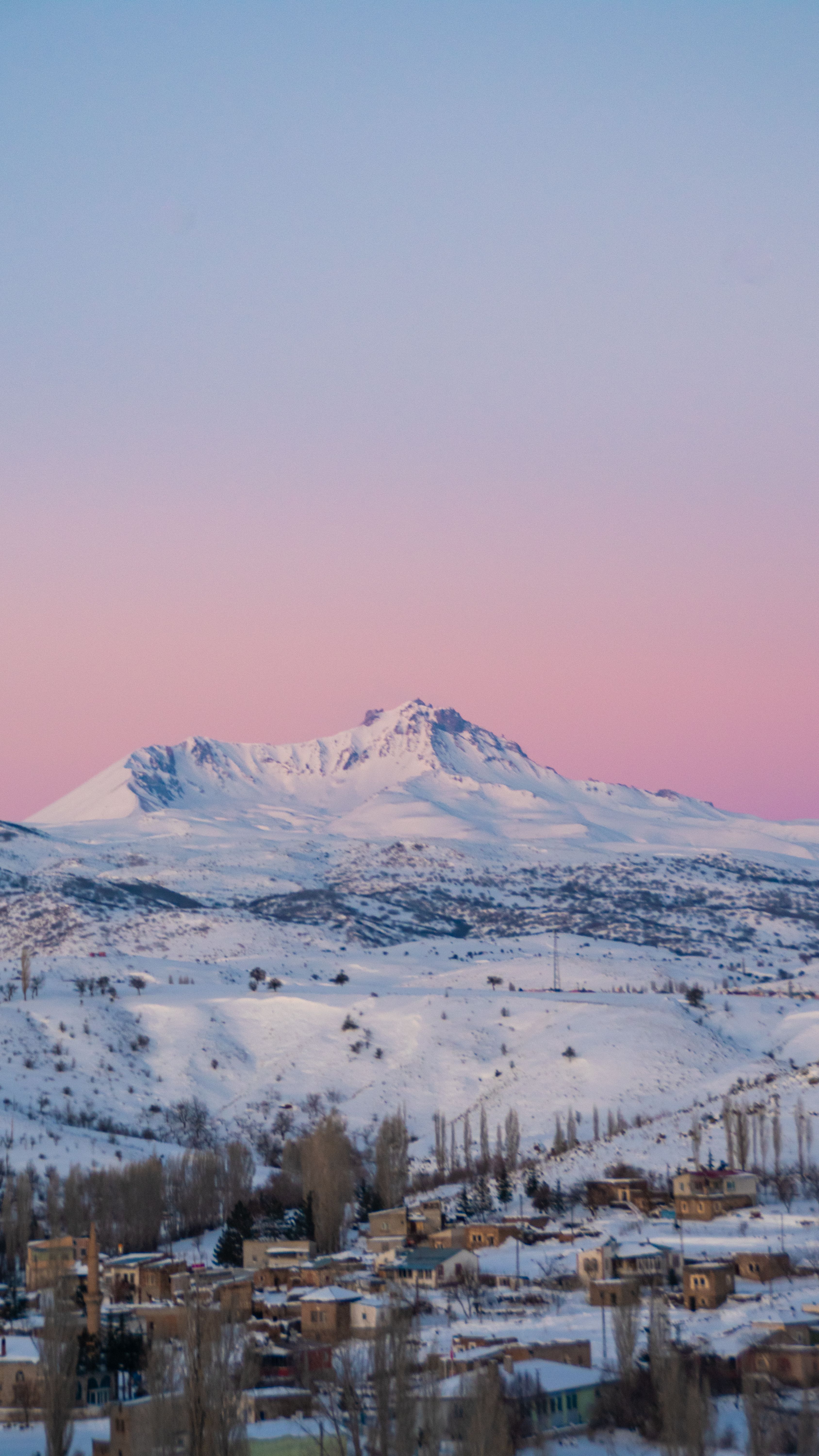 Stunning view of Erciyes Mountain with a pink sky and snow-covered landscape.
